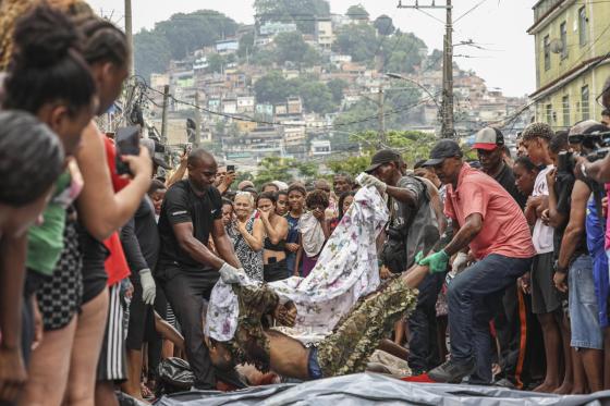 Personas acomodan cuerpos sin vida en una calle este miércoles, en Río de Janeiro (Brasil).