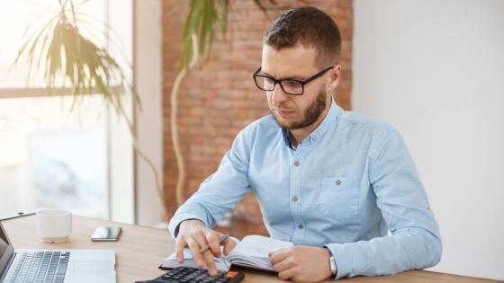 Hombre haciendo cuentas de cuánto le deben pagar si trabaja un 25 de diciembre.
