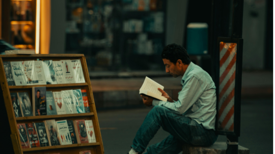 Hombre leyendo en una bilbioteca.